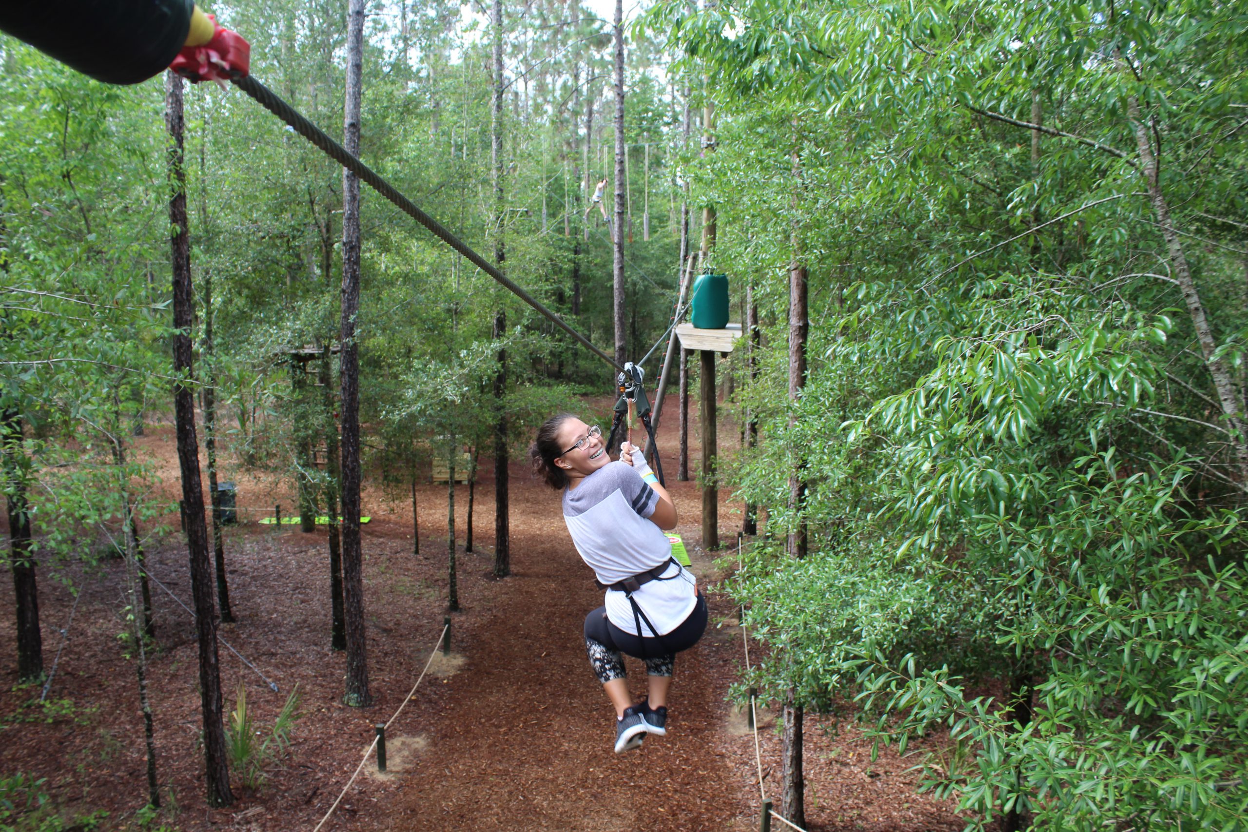 A girl ziplines through the treetops at Orlando Tree Trek.